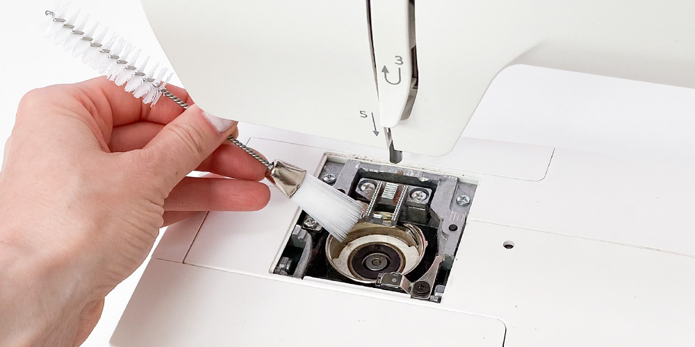 Czyszczeni kosza chwytacza w maszynie do szycia 