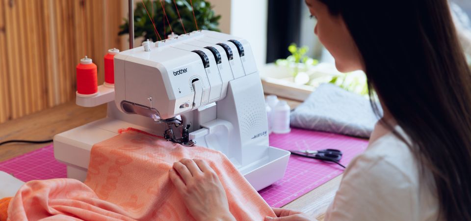 Kobieta szyje na owerloku Brother AirFlow 3000